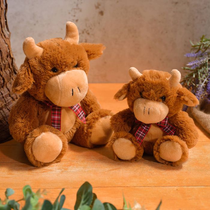 Small mooing highland cow with tartan bow