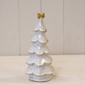Large stone glazed Christmas tree topped with a cream bow