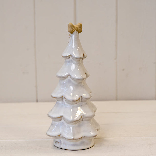 Large stone glazed Christmas tree topped with a cream bow