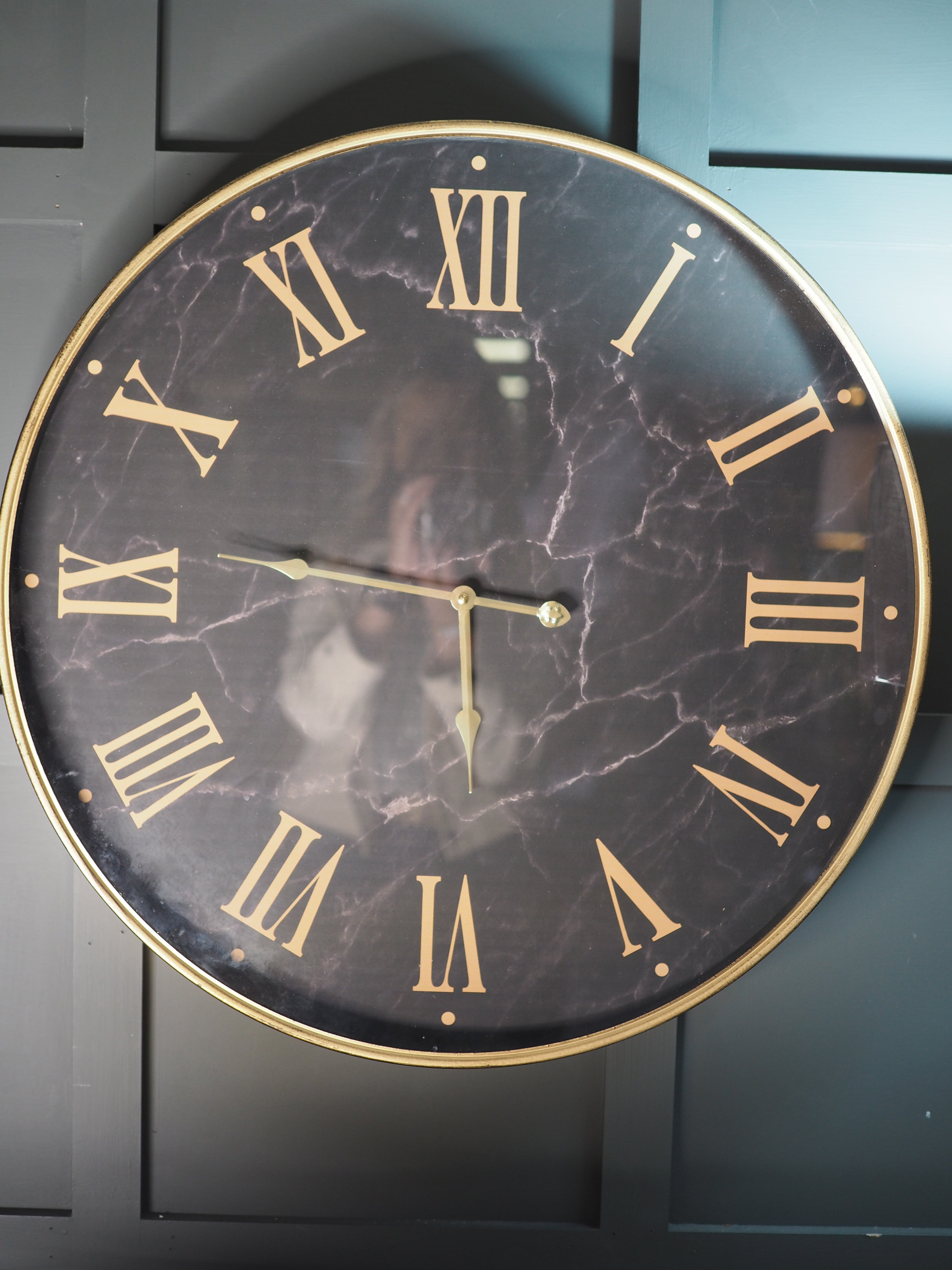 Black marble face clock with gold Roman numerals