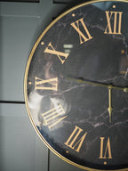 Black marble face clock with gold Roman numerals