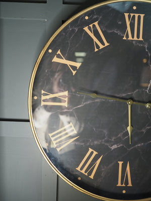 Black marble face clock with gold Roman numerals