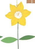 Two decorative flowers, one white with a yellow center and the other yellow with a white center, on a white background. There is also a cardboard packaging box with a flower design.