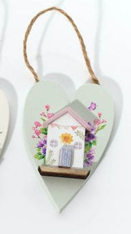 Three heart-shaped decorations with houses on a white background