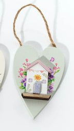 Three heart-shaped decorations with houses on a white background
