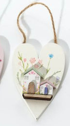 Three heart-shaped decorations with houses on a white background