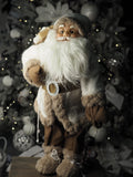 Santa with fur coat carrying his sack and bronze lantern
