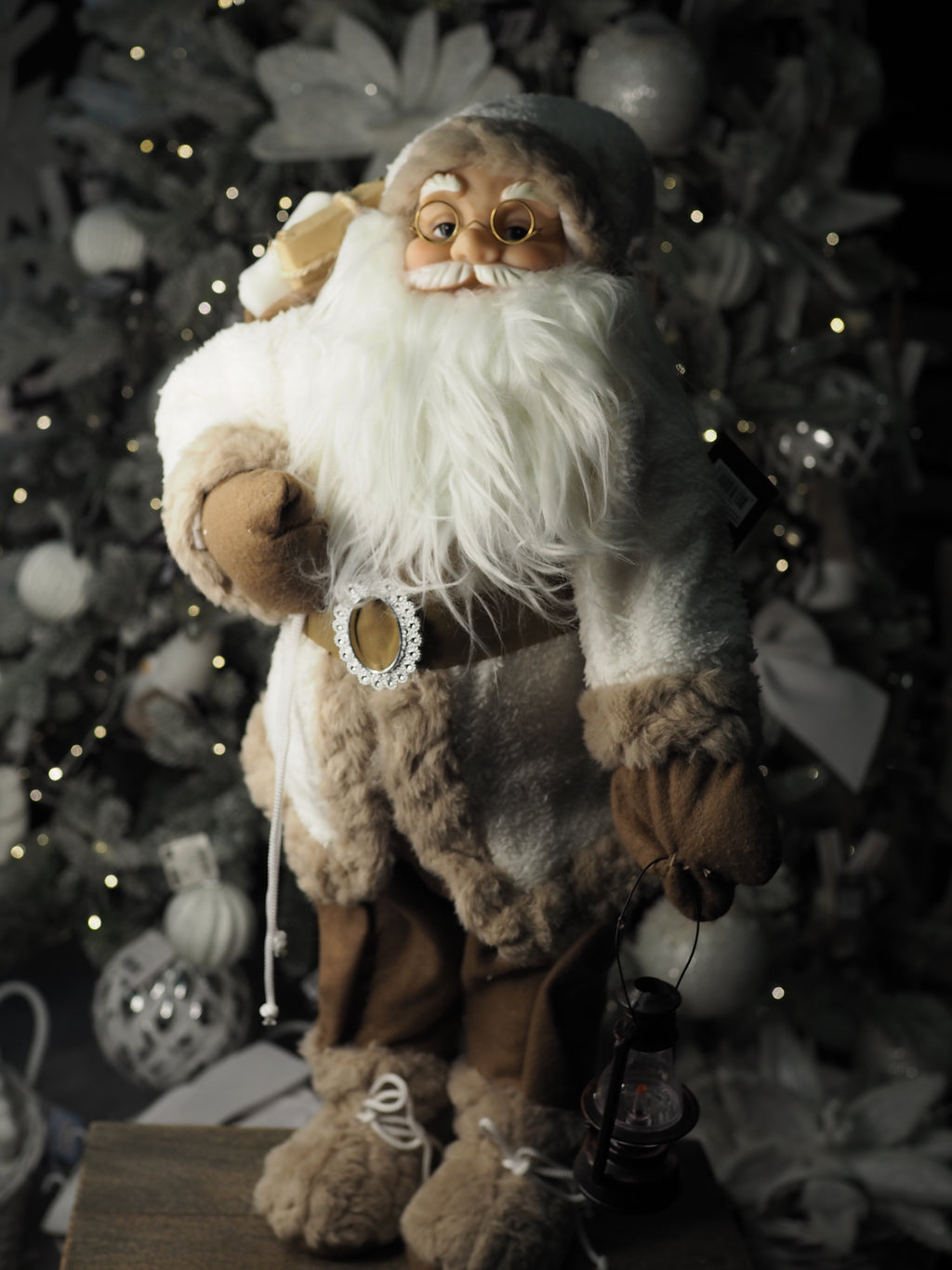 Santa with fur coat carrying his sack and bronze lantern