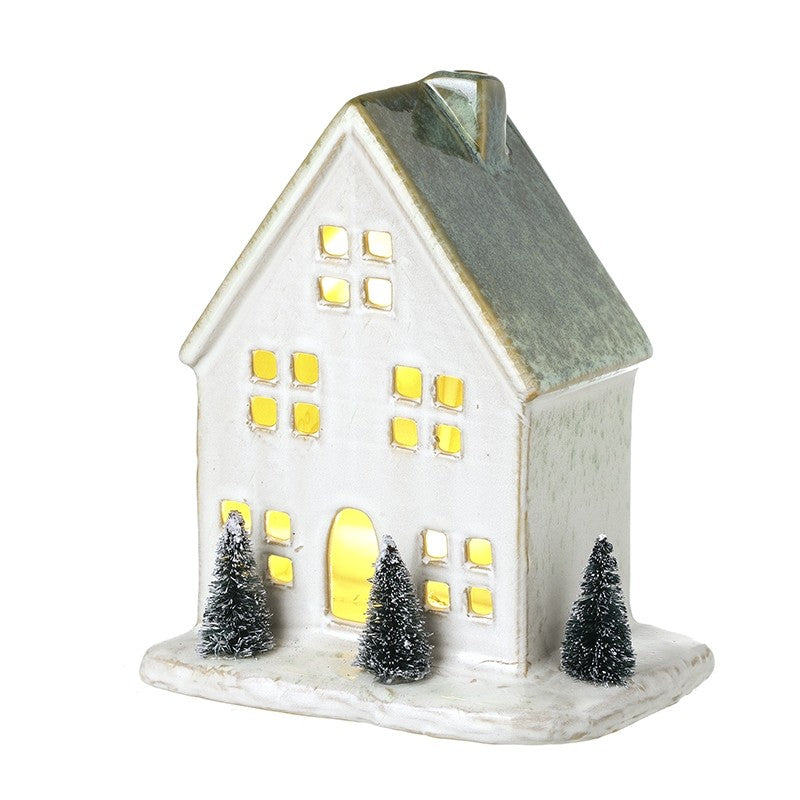 Light up white house with green fir trees