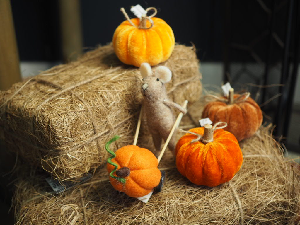 Brown felt mouse pushing pumpkin