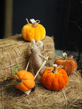 Brown felt mouse pushing pumpkin