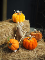 Brown felt mouse pushing pumpkin