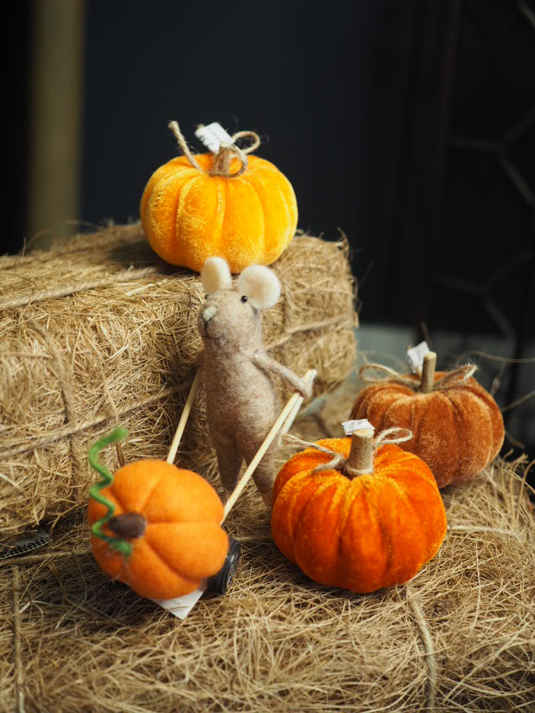 Brown felt mouse pushing pumpkin
