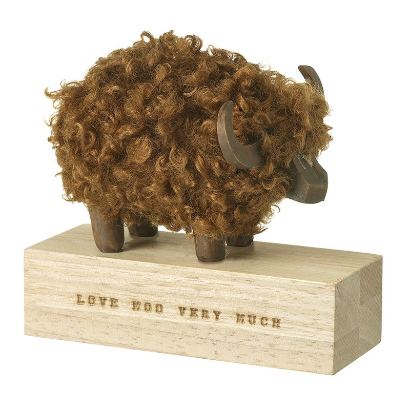 Highland cow on wooden block