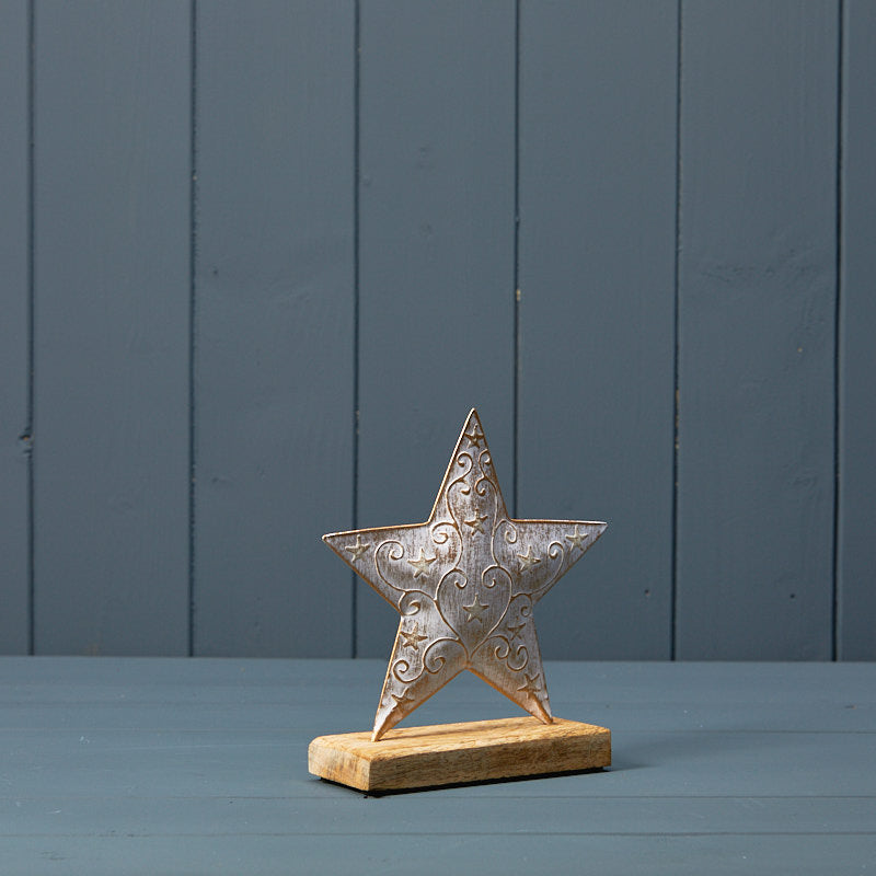 White and gold metal star on wooden base